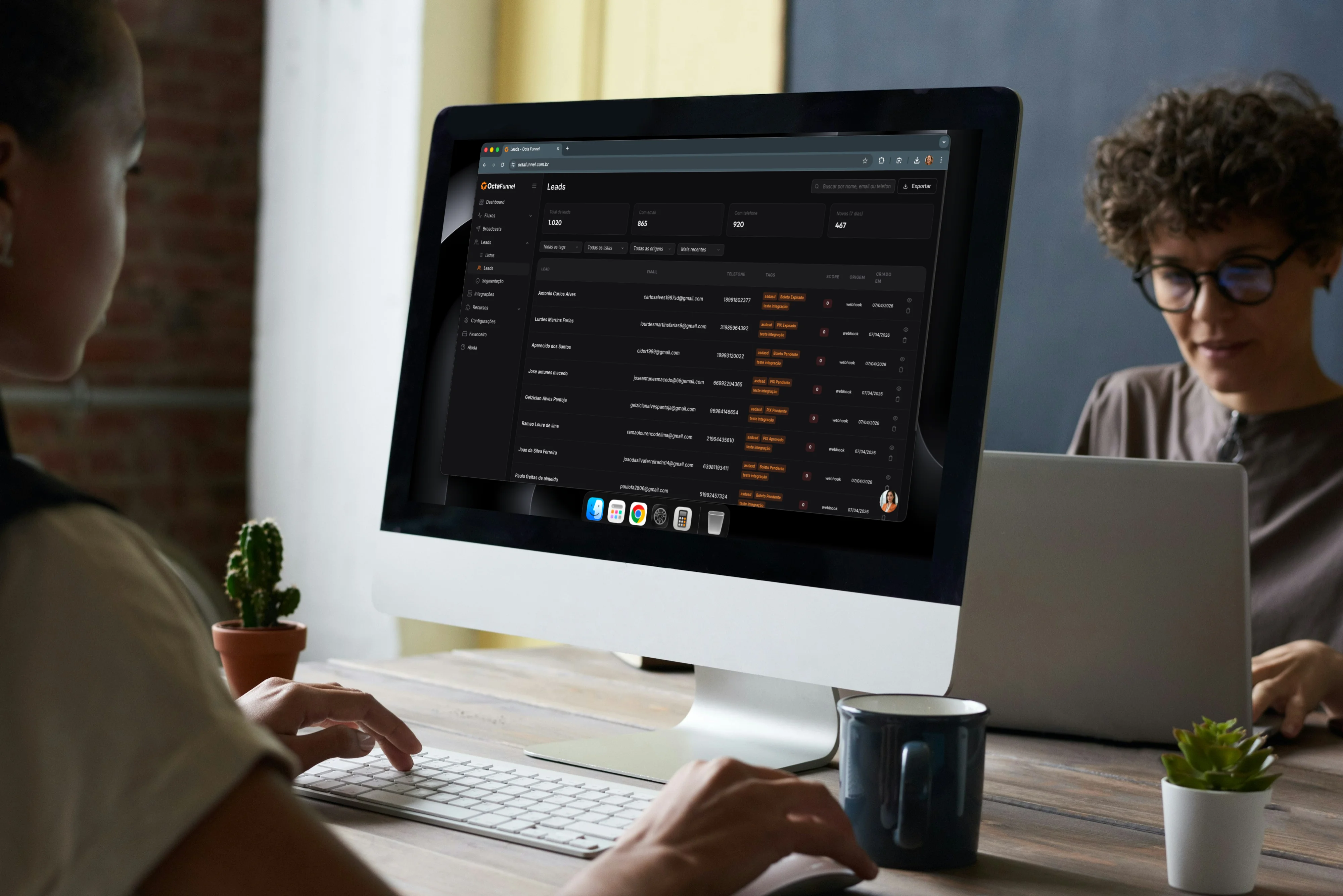 Equipe em iMac olhando tela de leads da Octa Funnel