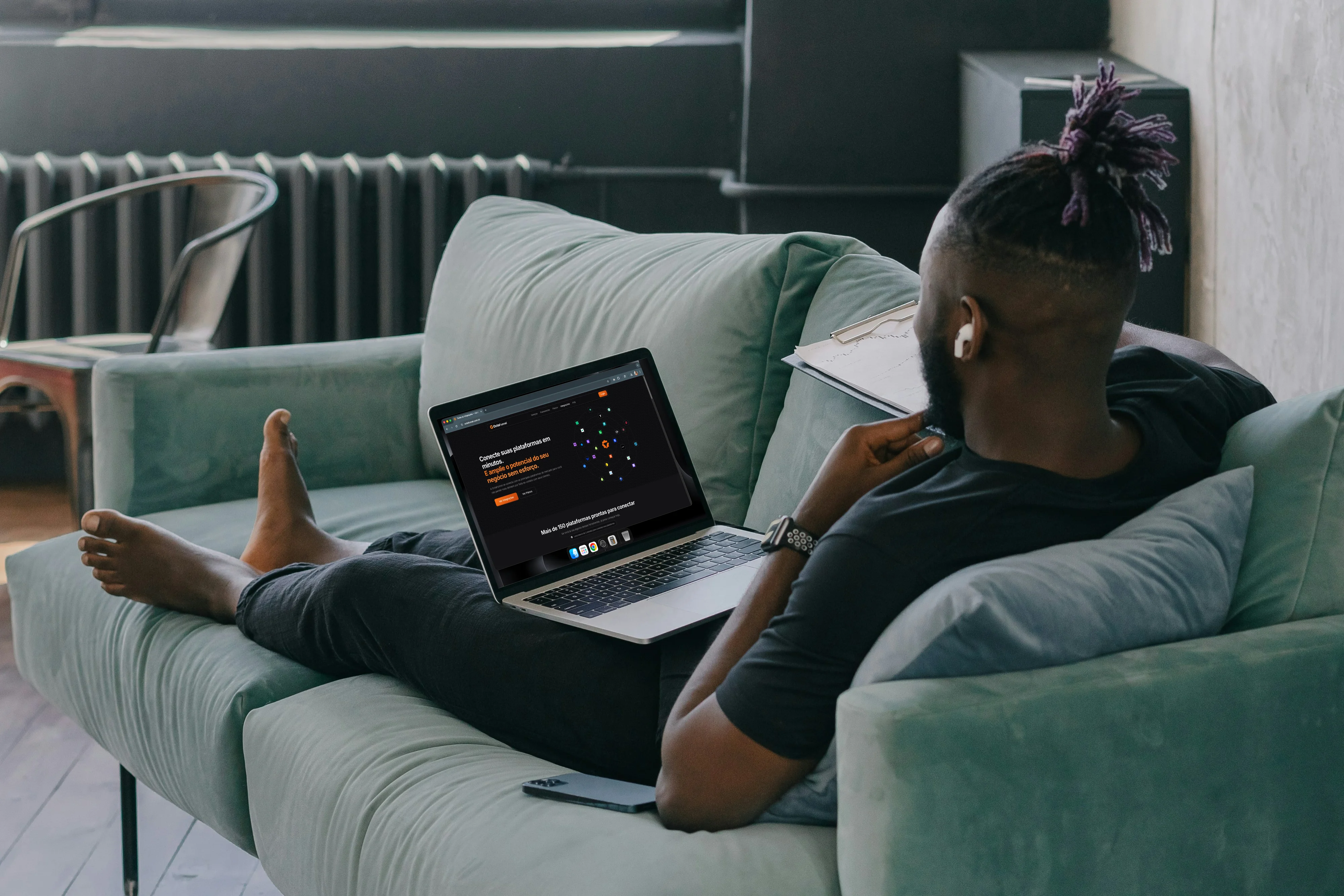 Homem no sofá com laptop em landing page da Octa Funnel