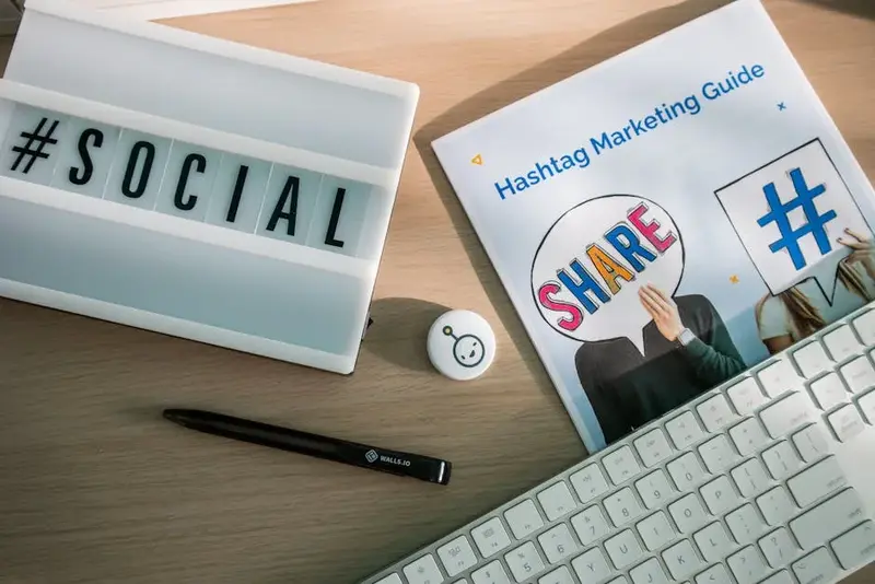 Setup de marketing digital com teclado e guia de redes sociais