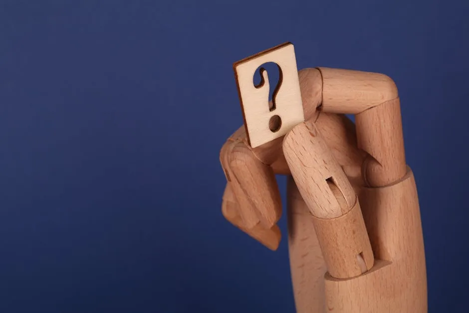 A symbolic wooden hand holding a question mark block against a blue background, representing curiosi