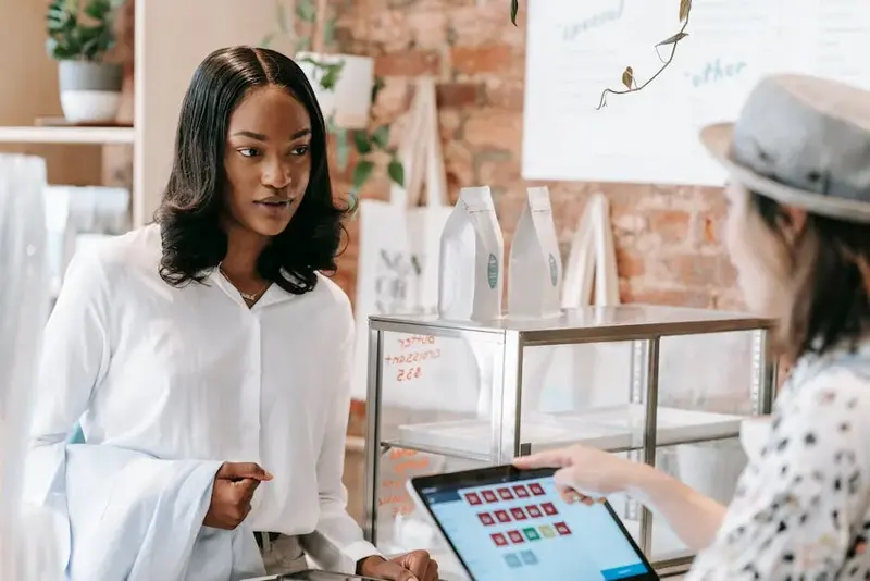 A customer interacts with a barista at a trendy coffee shop counter, showcasing modern retail servic